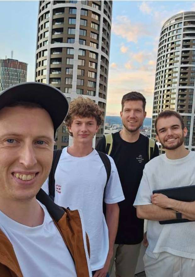 Four indie makers taking a selfie outdoors in the city